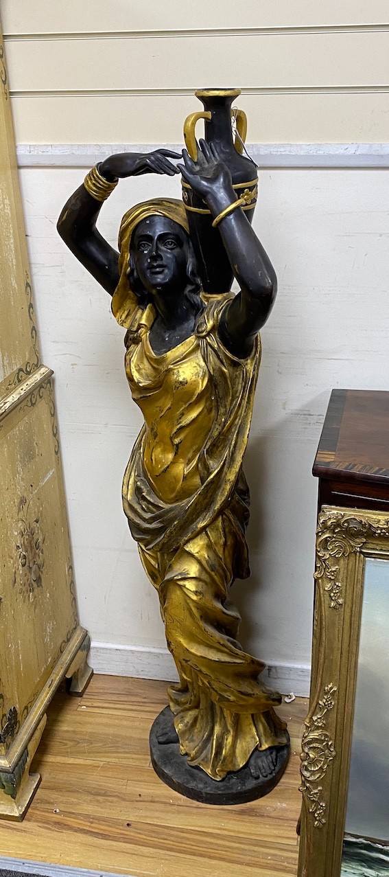 A pair of large gilded and brown patinated bronze figures of Nubian women holding amphoras, height 144cm